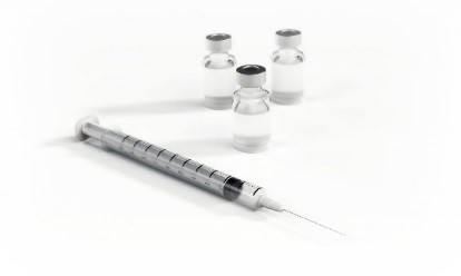 Private Flu Vaccines image, showing a syringe and small bottles of vaccines